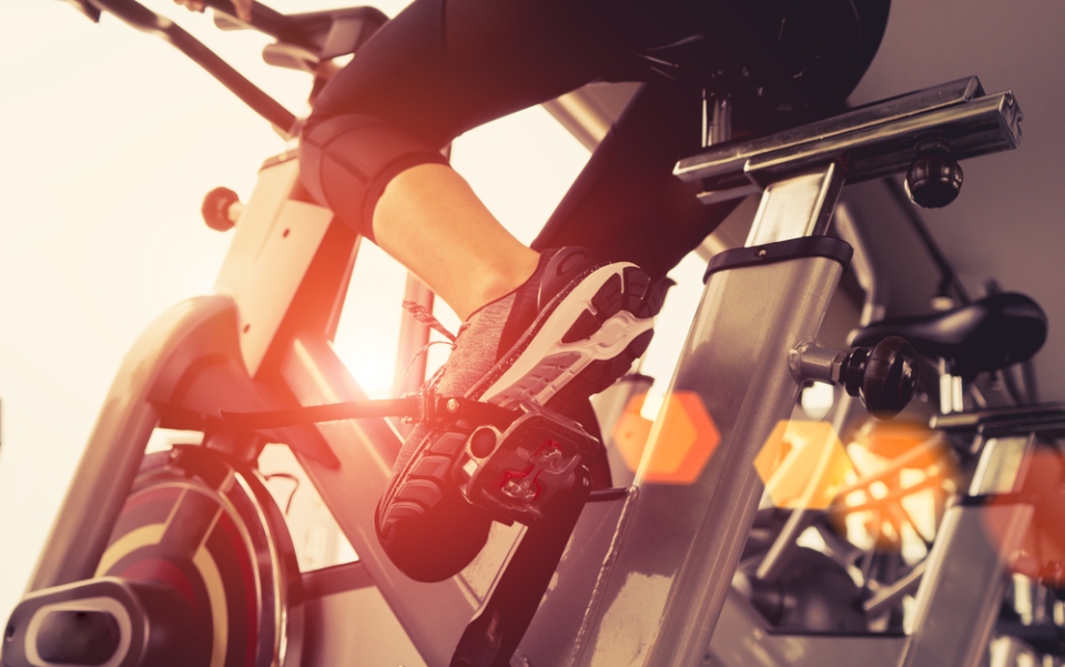 Un detalle de una mujer realizando cardio en una bicicleta de un gimnasio.